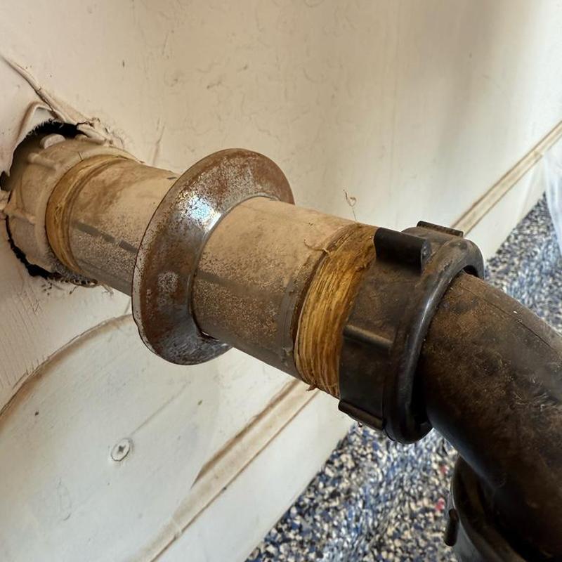 Utility sink drain pipe with tightening coupling in wall