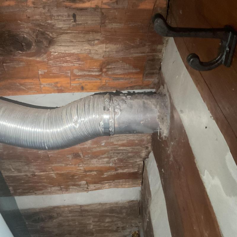 Dryer vent duct secured to wall with clamp Dryer vent duct secured to wall with clamp
