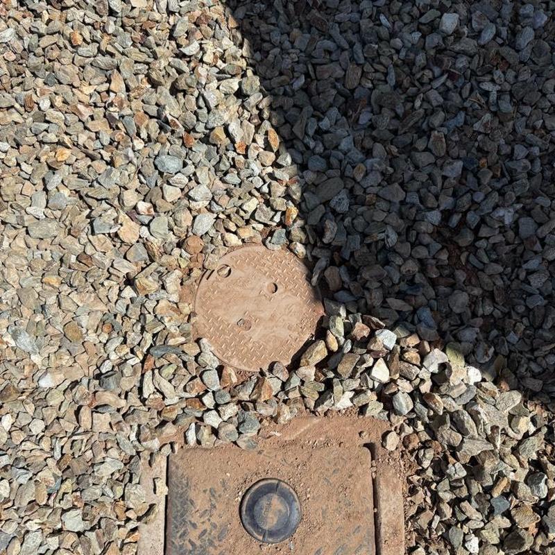 Water pressure regulator access box set in gravel bed