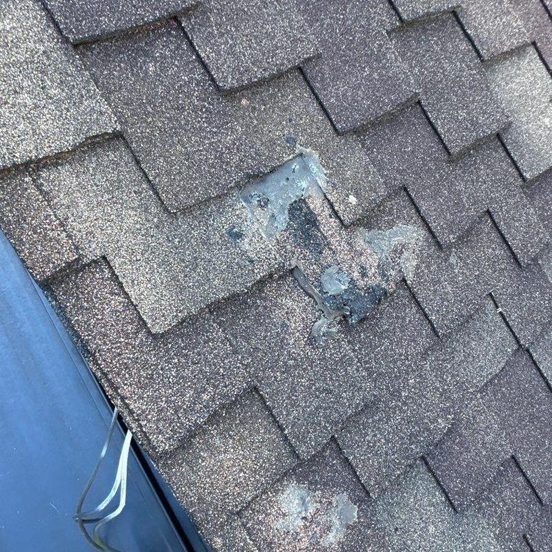 Asphalt shingle roof with hail damage near flashing