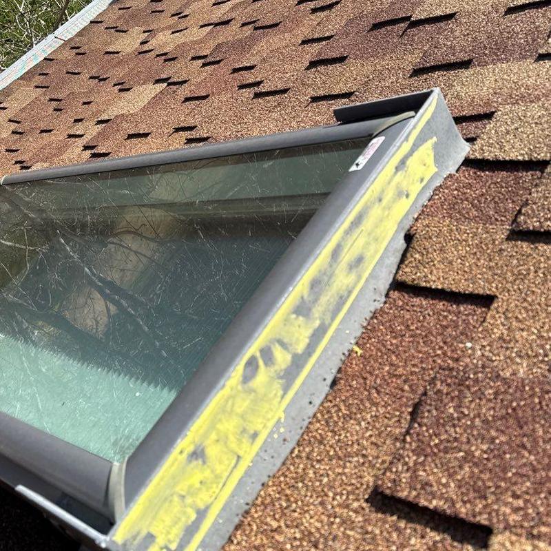 Skylight flashing with weatherproofing on roof shingles