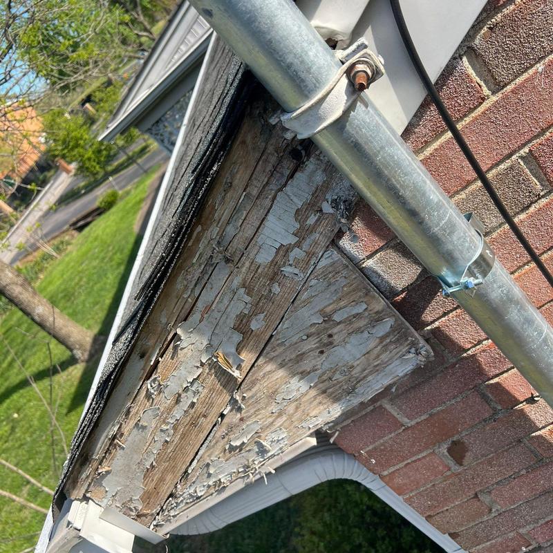 Wood fascia board with peeling paint and wear