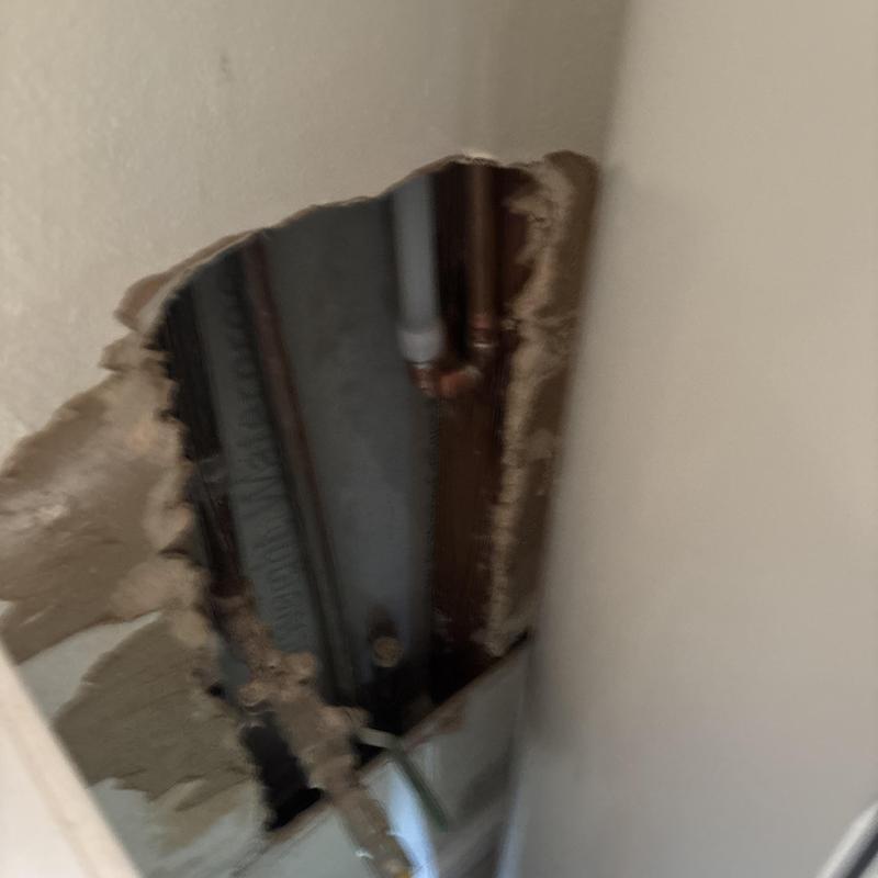 Copper water pipes behind drywall access hole