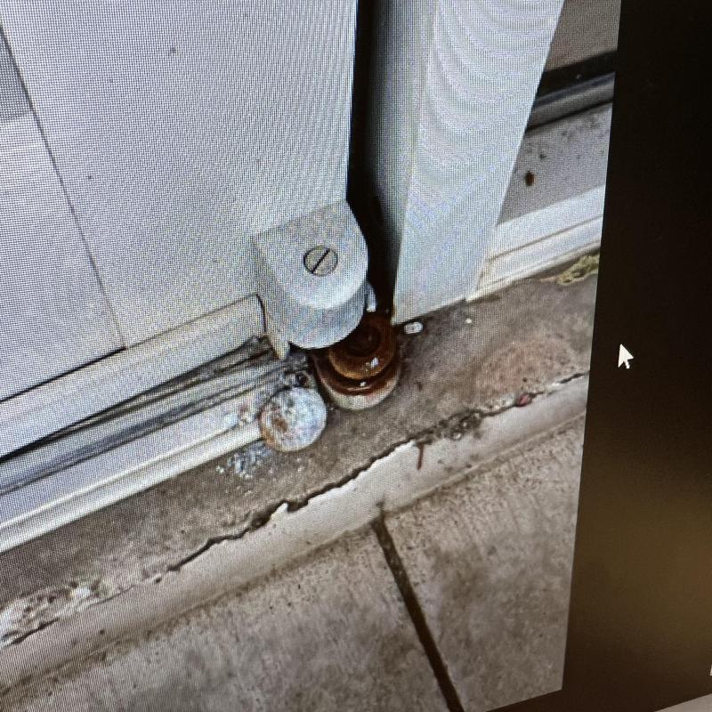 Front door lower pivot and hinge assembly on concrete