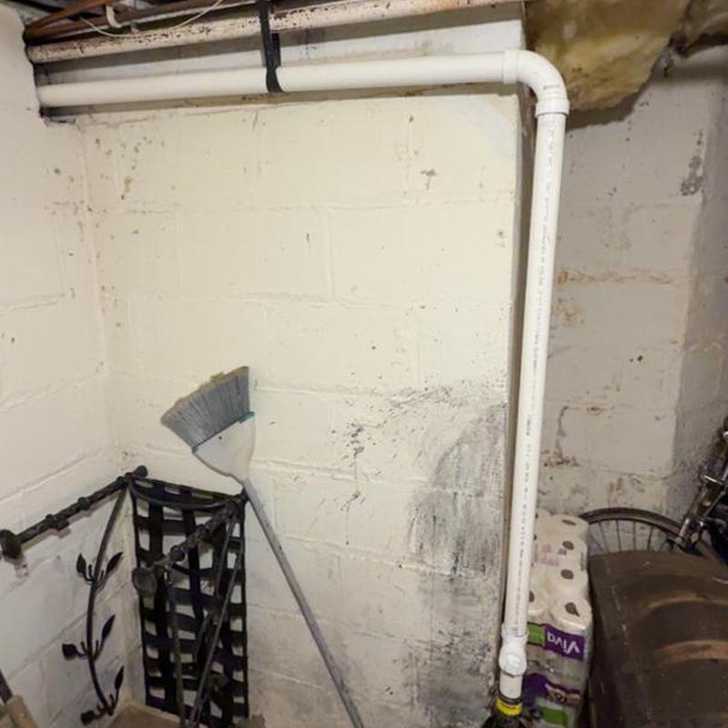Kitchen sink PVC drain pipe installation in basement corner