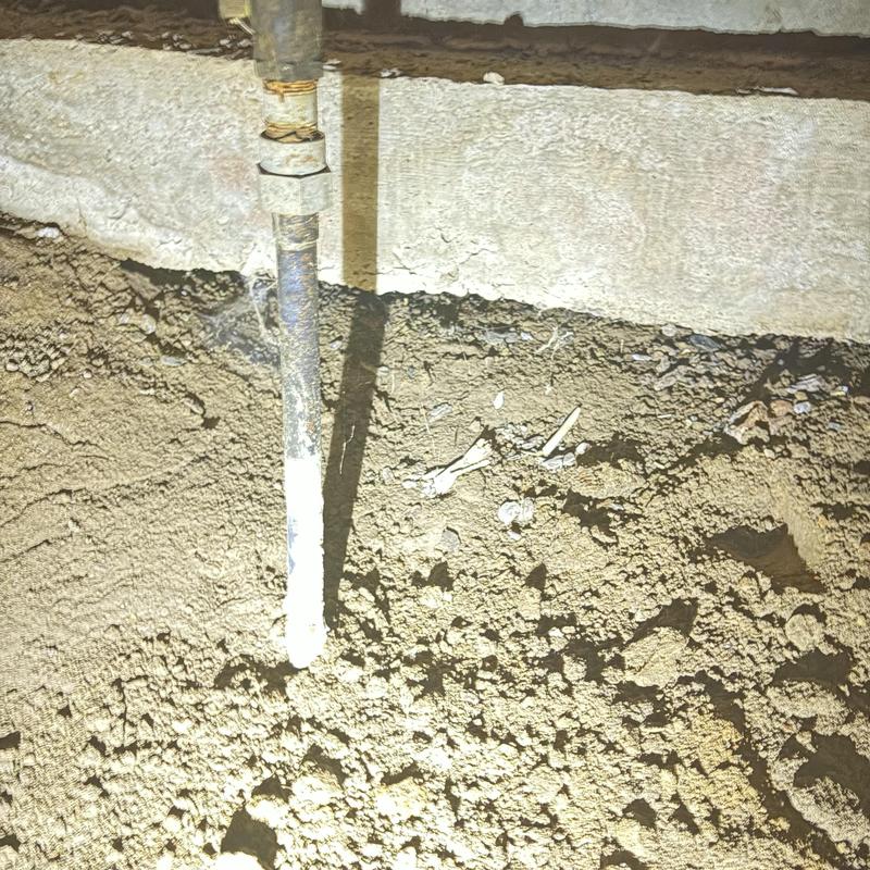 Water main pipe exposed in yard soil near foundation Water main pipe exposed in yard soil near foundation