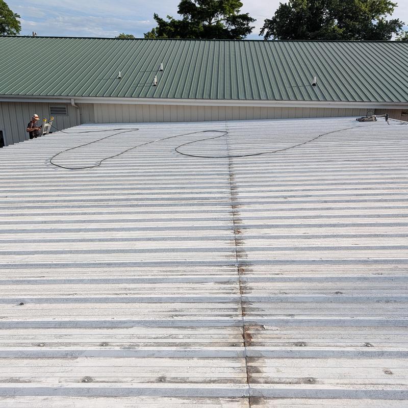 Commercial metal roof with restoration equipment