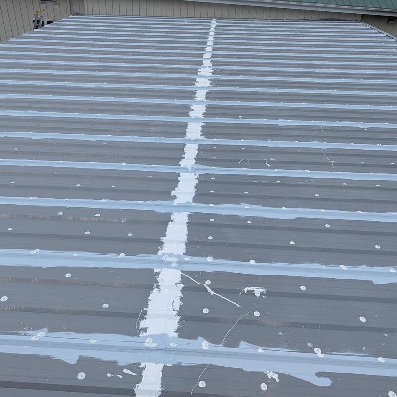 Commercial metal roof with elastomeric seam sealant