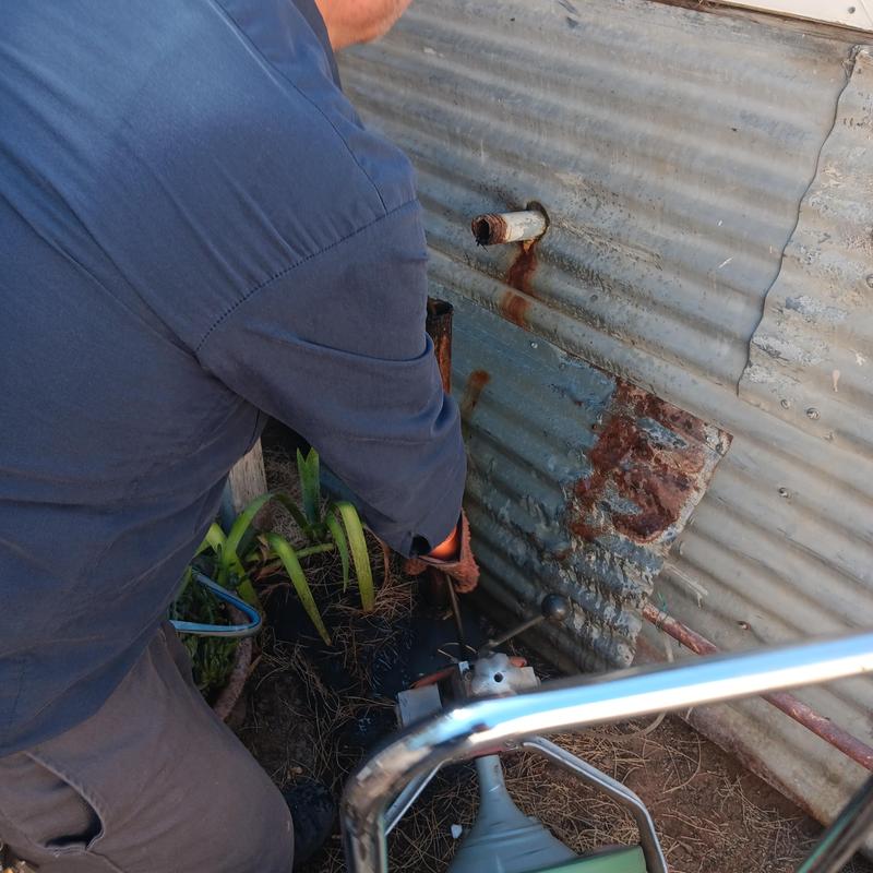 Kitchen sink cleanout pipe with plumbing snake cleaning blockage