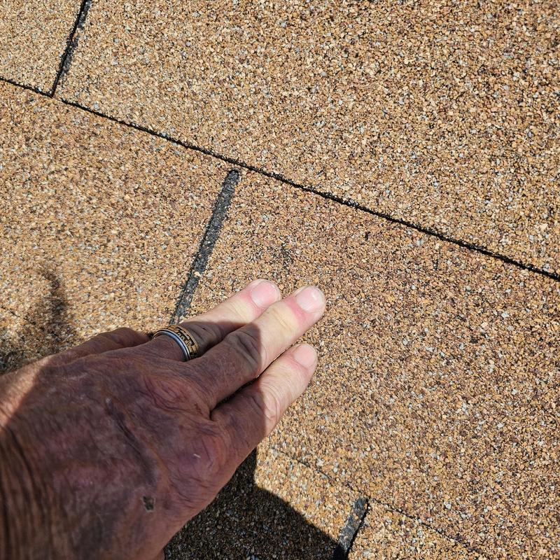 Asphalt roof shingles with hail damage close-up