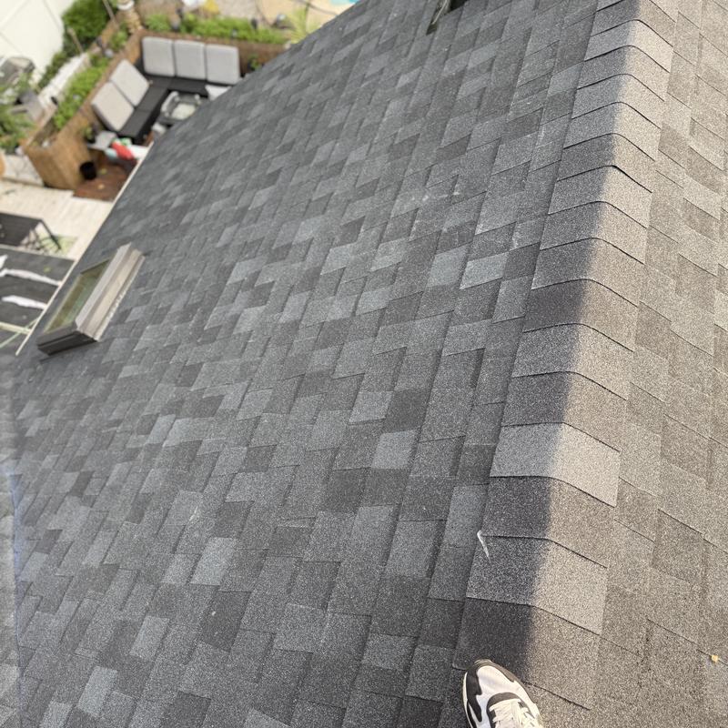 Asphalt shingle roof with new ridge cap installation
