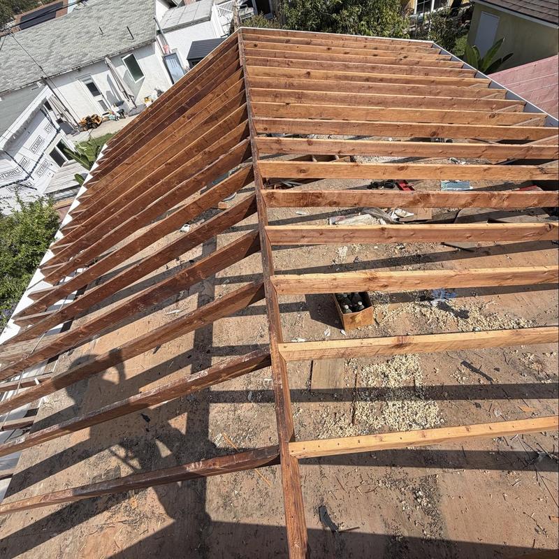 Roof framing with exposed wooden rafters under construction