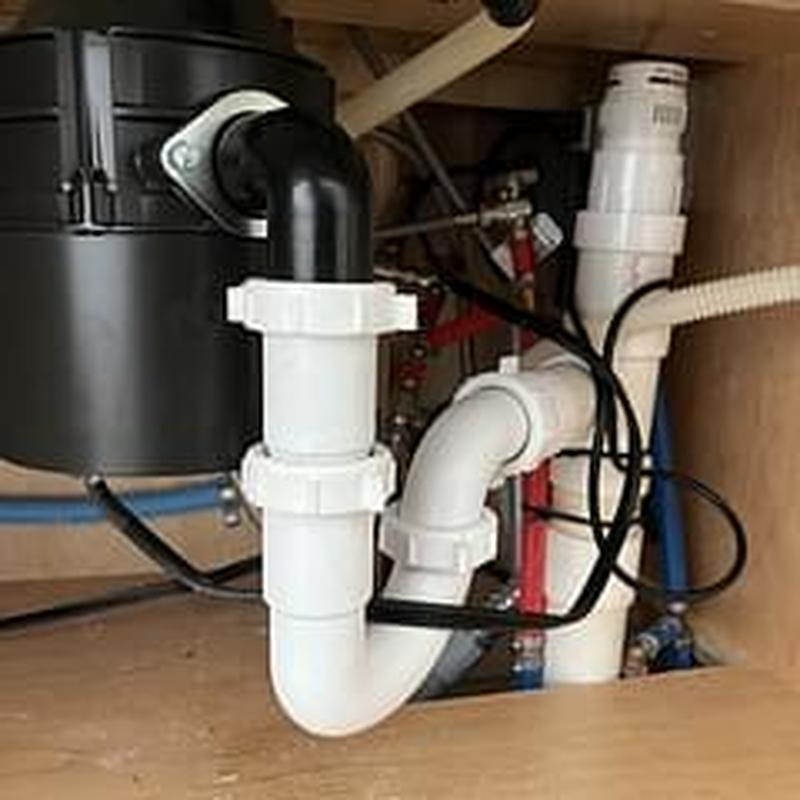 Sink drain trap and plumbing connections under cabinet