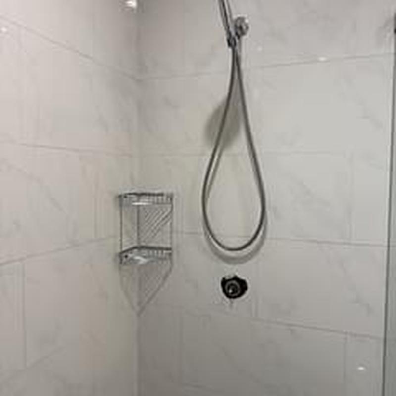 Shower tower with handheld showerhead and tiled wall Shower tower with handheld showerhead and tiled wall