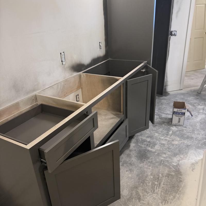 Gray kitchen cabinets installation with fresh paint nearby