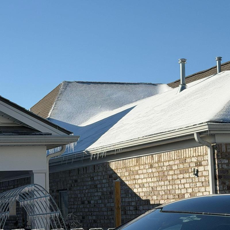 Roof shingles with hail damage and icicles forming