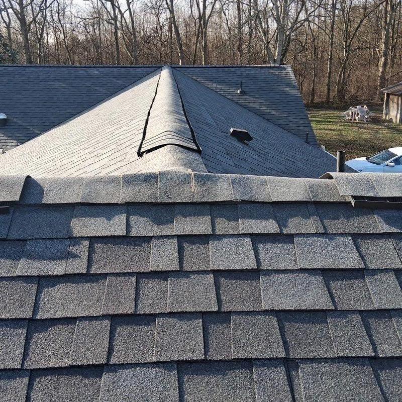 Asphalt shingle roof with damaged ridge cap shingles
