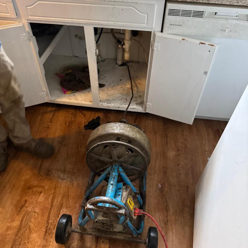 Kitchen drain line cable machine in use under cabinet