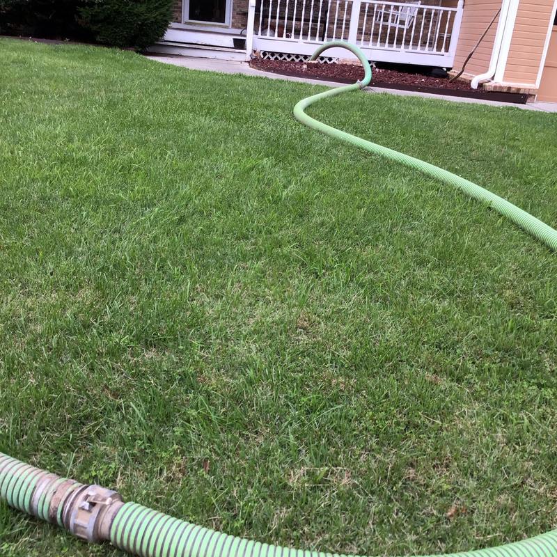 Septic tank hose on lawn near residential house