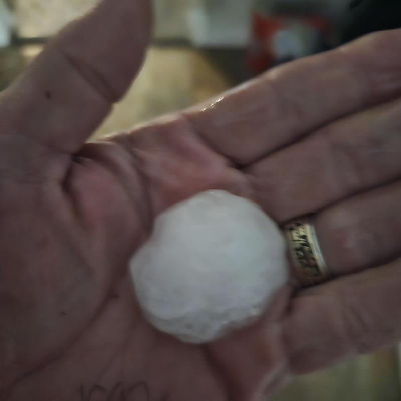 Hailstone in hand showing hail damage size