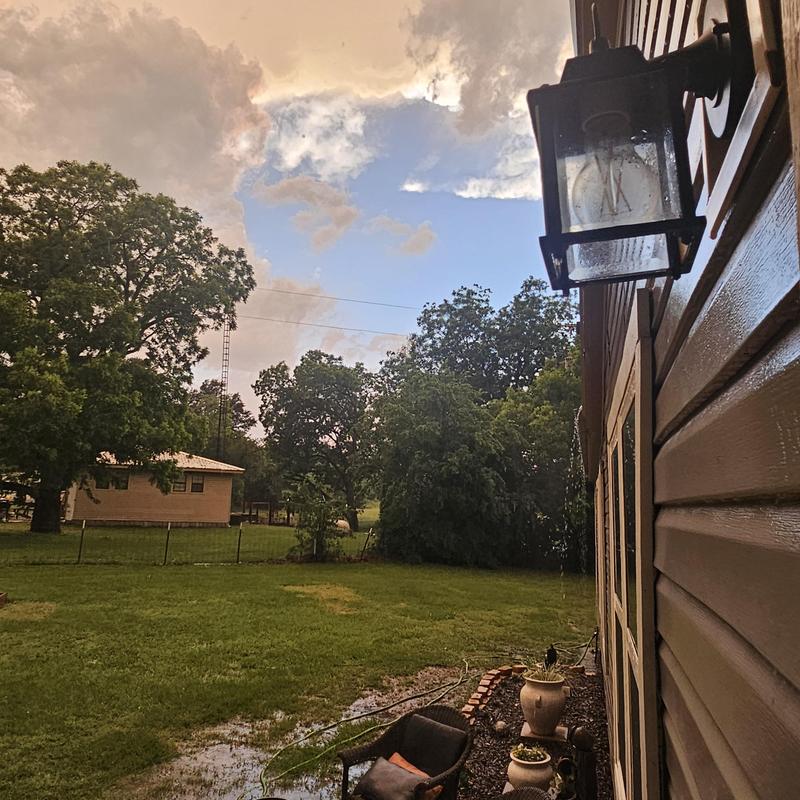Exterior wall light fixture with hail damage on siding