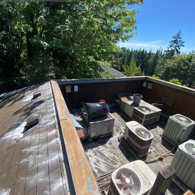 Rooftop HVAC units on flat roof under bright sunlight