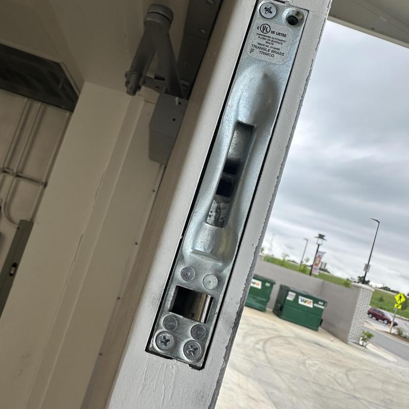 Flush bolt on commercial metal door frame outdoors