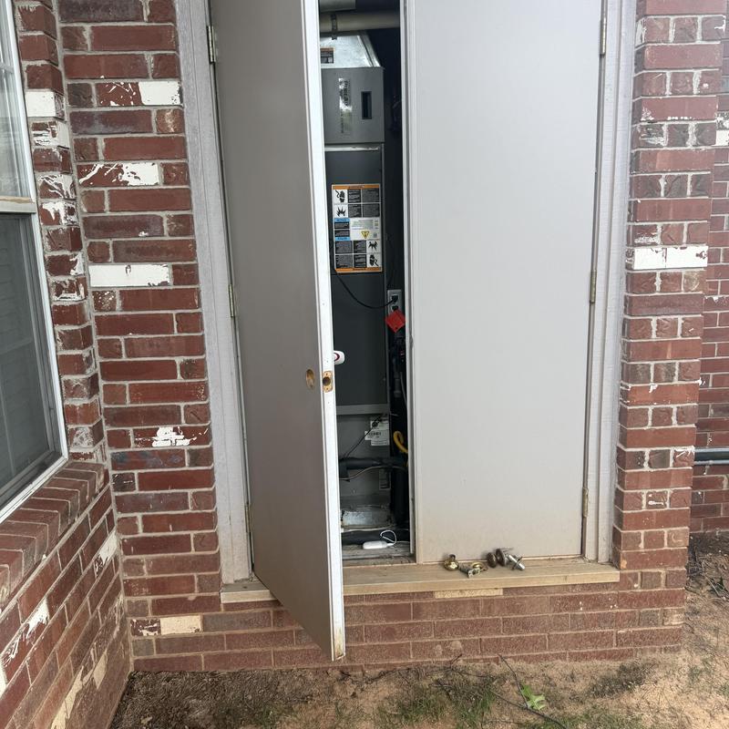 AC closet door with new lock installation in brick wall