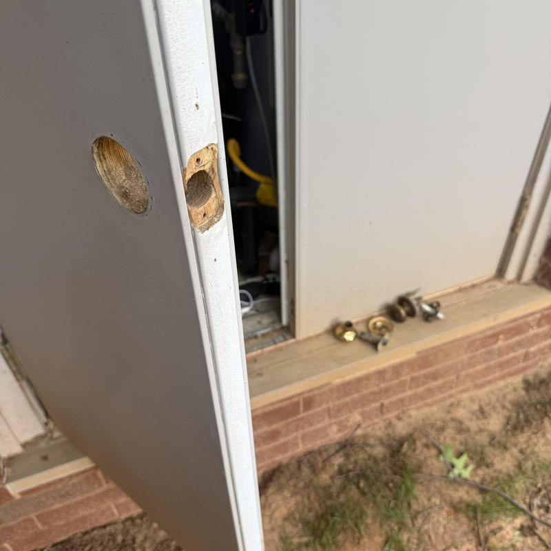 AC closet door with removed lock hardware outdoors