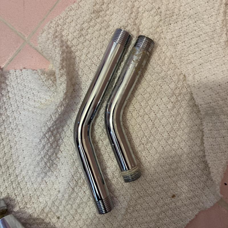 Shower faucet arms showing new and old replacement