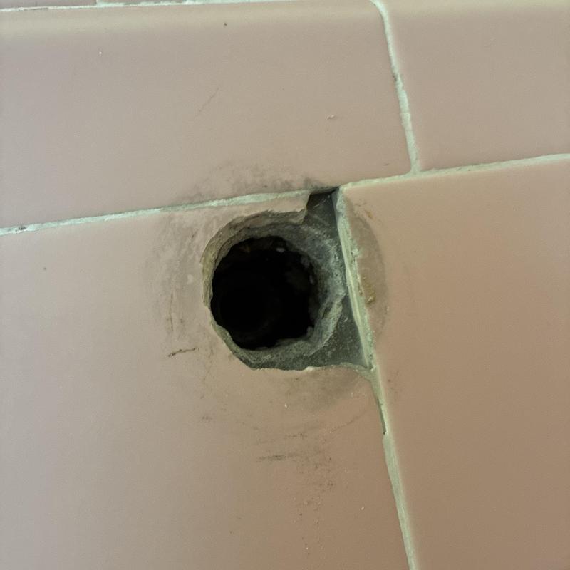 Shower faucet mounting hole in tiled wall