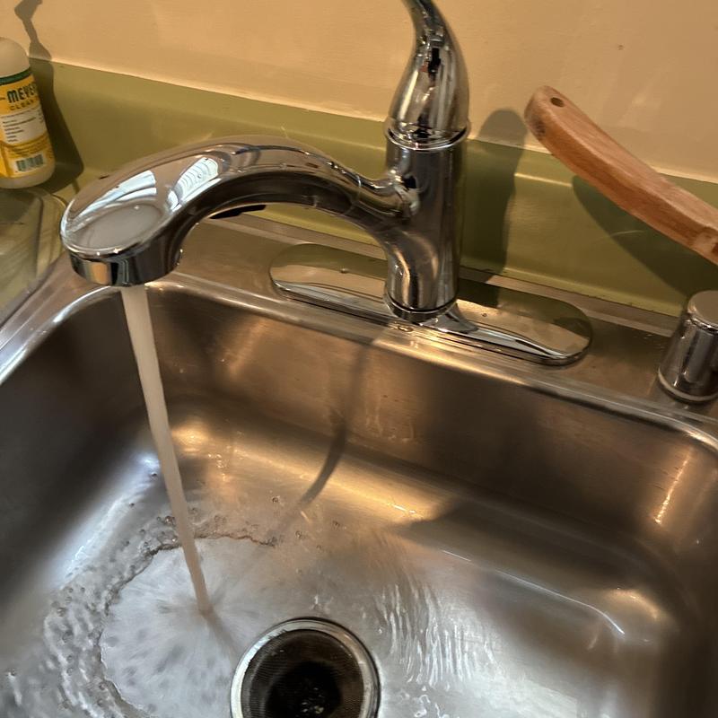 Kitchen faucet with running water in stainless sink
