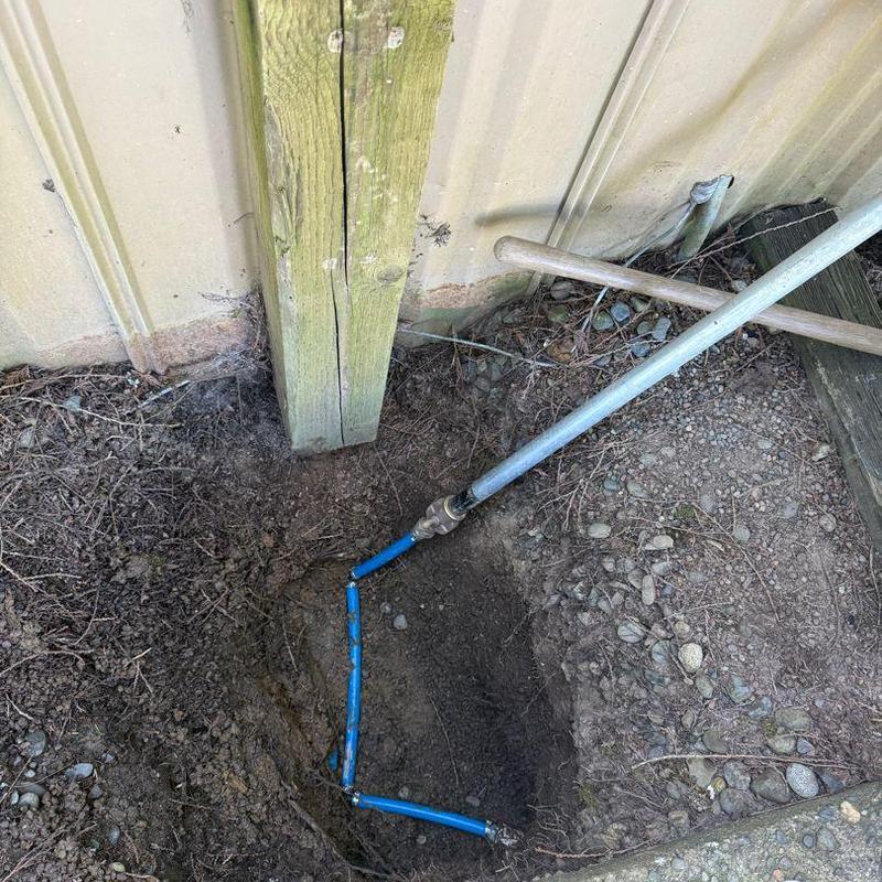 Blue water line connection near building foundation Blue water line connection near building foundation