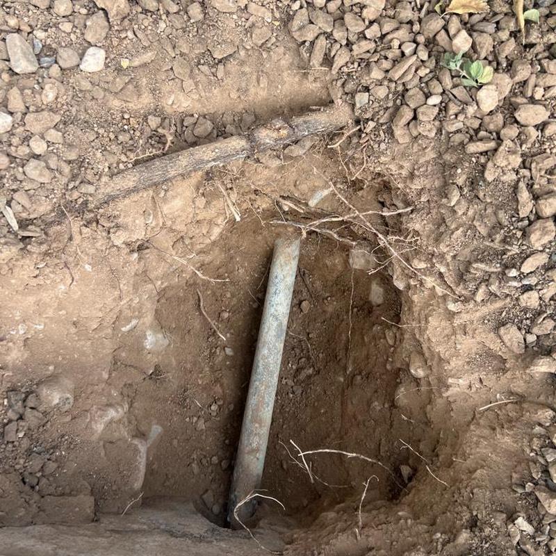 Main water line excavation with exposed pipe underground