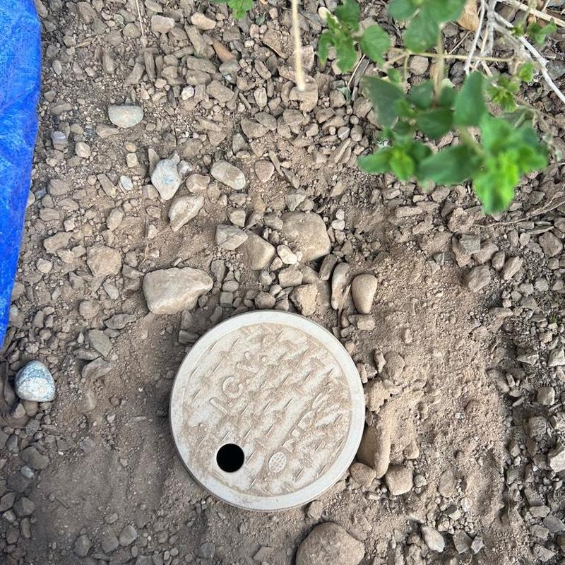 Pressure regulator valve box installed in soil with rocks