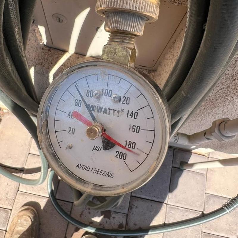 Pressure gauge on water line valve showing PSI reading