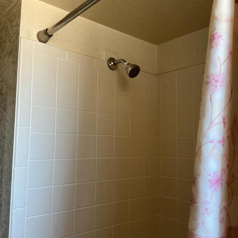 Tub shower valve installation with chrome trim and curtain
