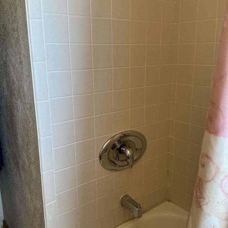 Tub shower valve with chrome trim installed in tub area