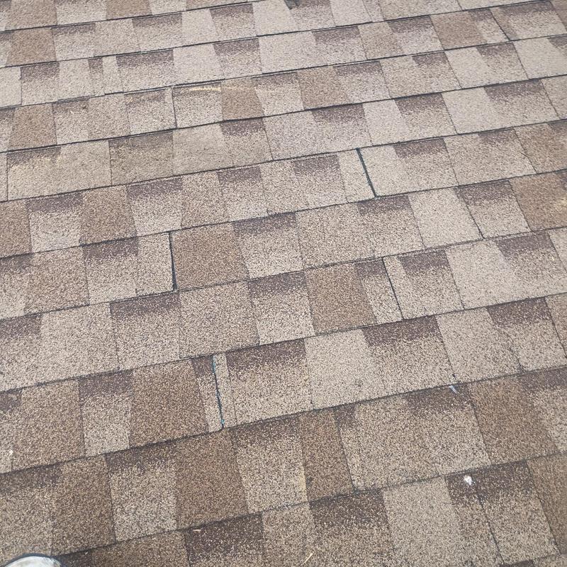 Asphalt roof shingles with minor damage and debris removal