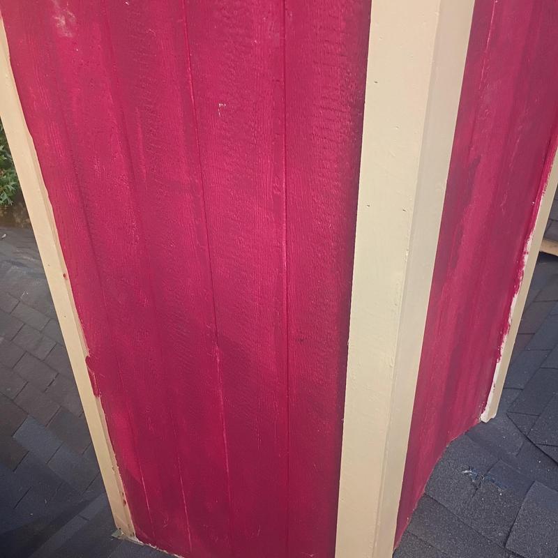 Corner boards with fresh red paint on house exterior
