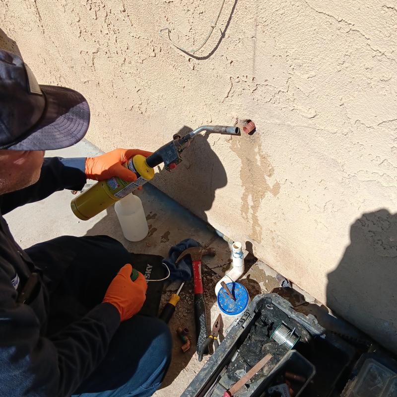 Outdoor hose bib replacement with torch in backyard
