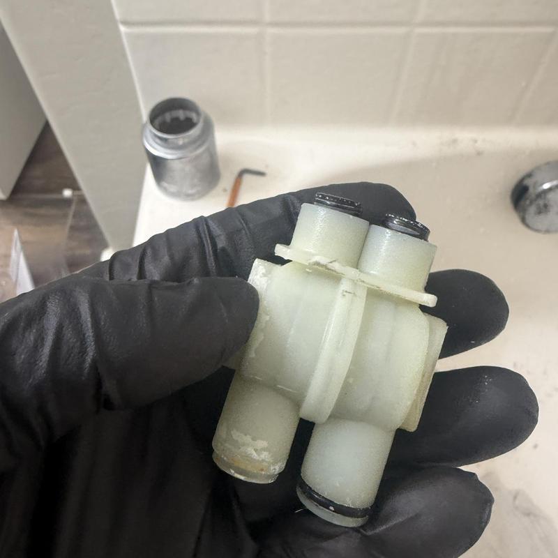 Delta shower cartridge held by gloved hand