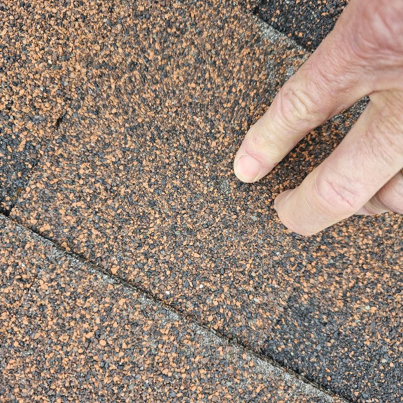 Asphalt shingle roof with hail damage impact area
