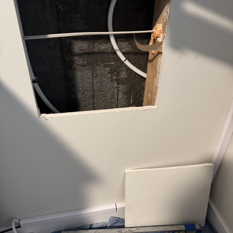 Hot water line with access hole in drywall wall Hot water line with access hole in drywall wall