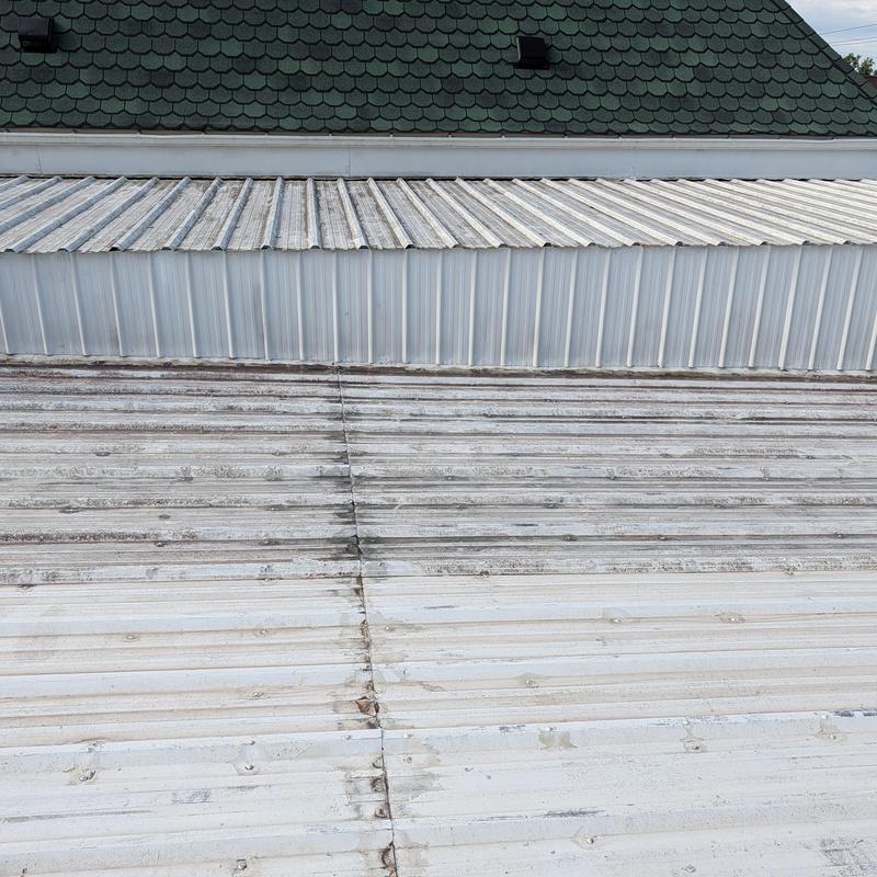 Commercial metal roof with aging coating and rust spots