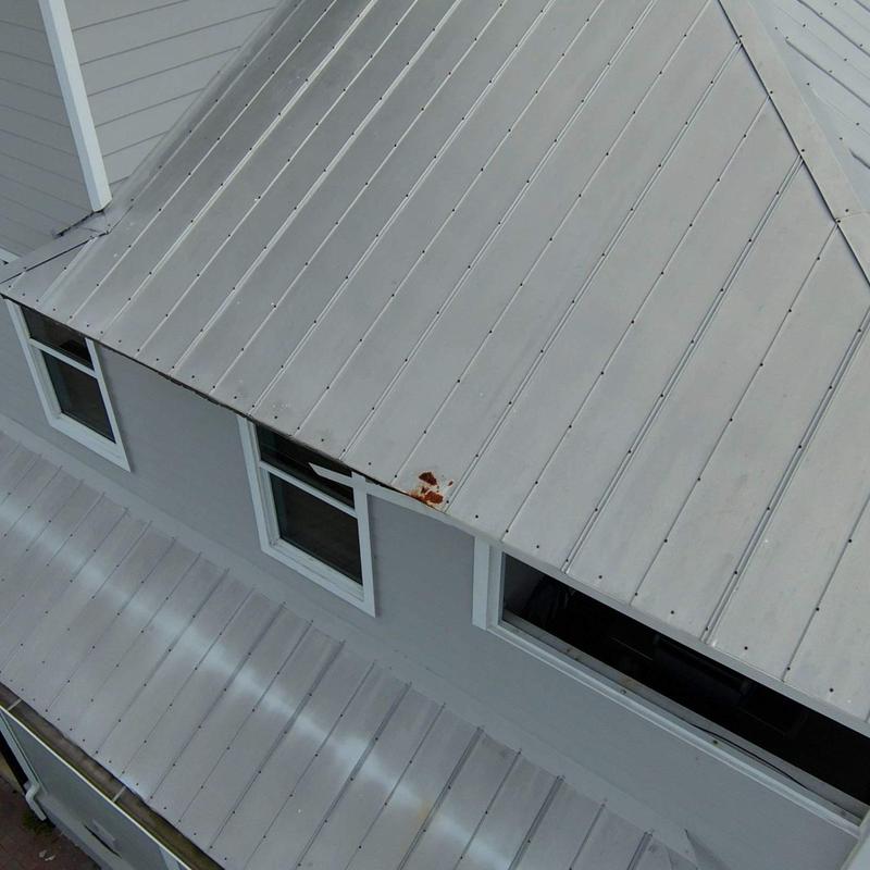 Metal roof panel with corrosion near window Metal roof panel with corrosion near window
