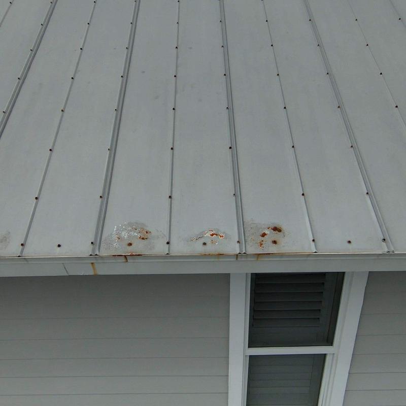 Metal roof panels with rust and corrosion near edge Metal roof panels with rust and corrosion near edge