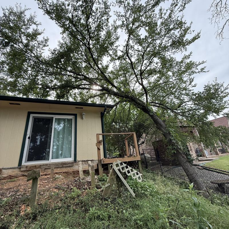 Leaning tree over house and damaged fence Leaning tree over house and damaged fence