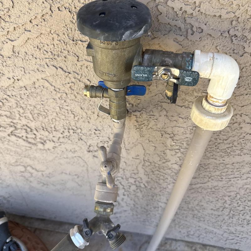 Backflow preventer and outdoor faucet assembly