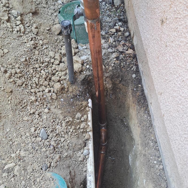 Copper water main pipe in trench near foundation wall Copper water main pipe in trench near foundation wall
